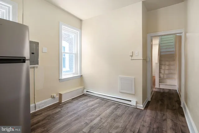 an empty room with wooden floor and a window