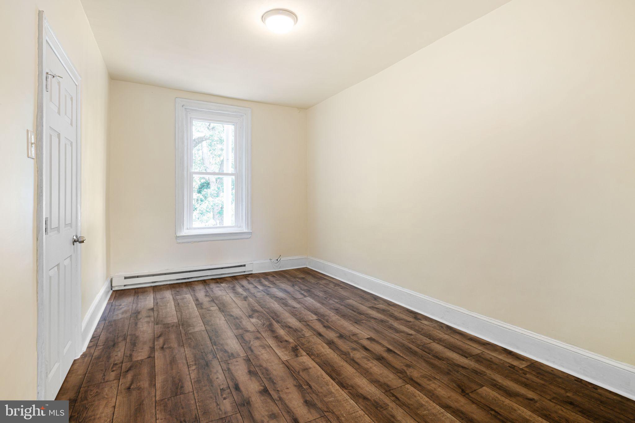 7153 Germantown Avenue, Unit 4 Philadelphia, PA 19119 - Photo 9 of 11 an empty room with wooden floor and windows