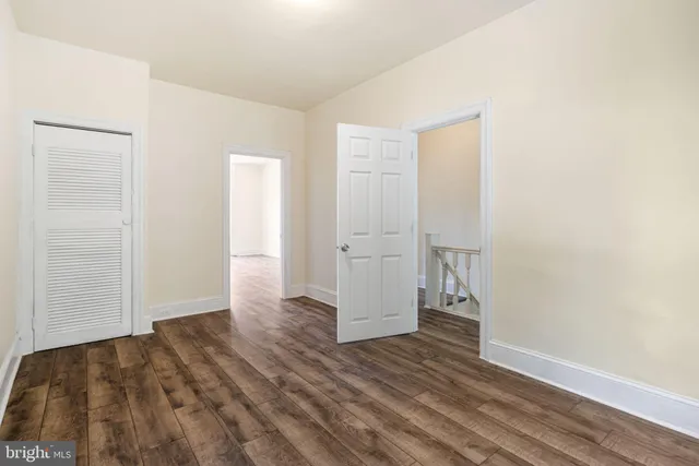 an empty room with wooden floor and closet