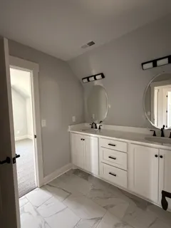 a bathroom with a double vanity sink a mirror and a bathtub