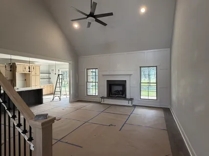 a view of an empty room with a fireplace and a window