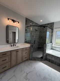 a bathroom with a double vanity sink mirror and bathtub