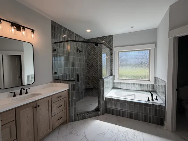 a bathroom with a tub sink toilet and mirror