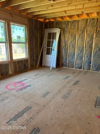 a view of a room with door and windows