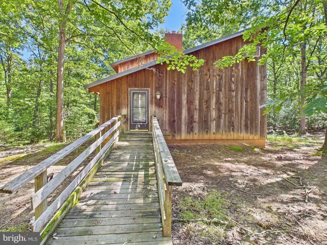 a view of a house with backyard and wooden fence