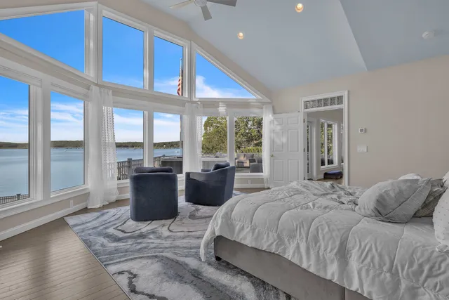 a bedroom with a large bed and windows