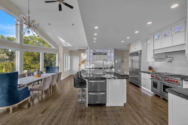 a kitchen with stainless steel appliances a stove a sink a refrigerator and wooden floor