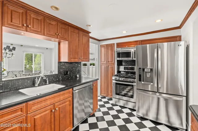 a kitchen with stainless steel appliances granite countertop a refrigerator and a sink