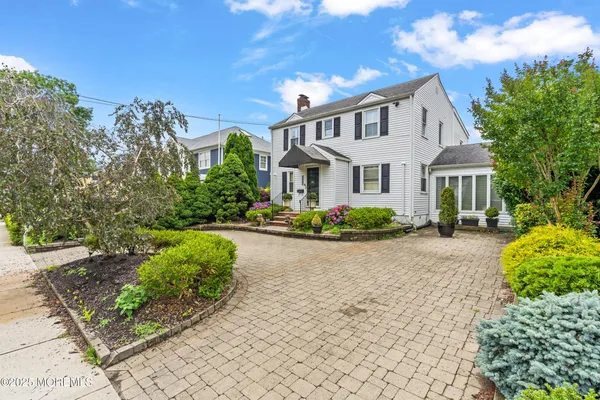 a front view of a house with a yard and potted plants