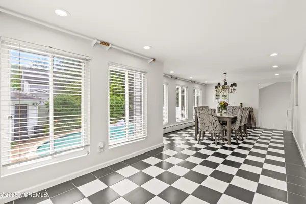 a dining room with a black white checkered floor with a dining table and chairs
