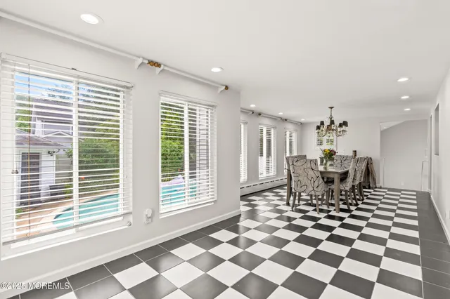 a dining room with a black white checkered floor with a dining table and chairs