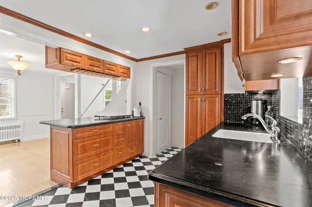 a kitchen with granite countertop a stove a sink and a refrigerator