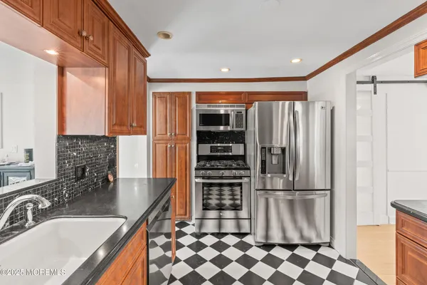 a kitchen with granite countertop a refrigerator and a sink