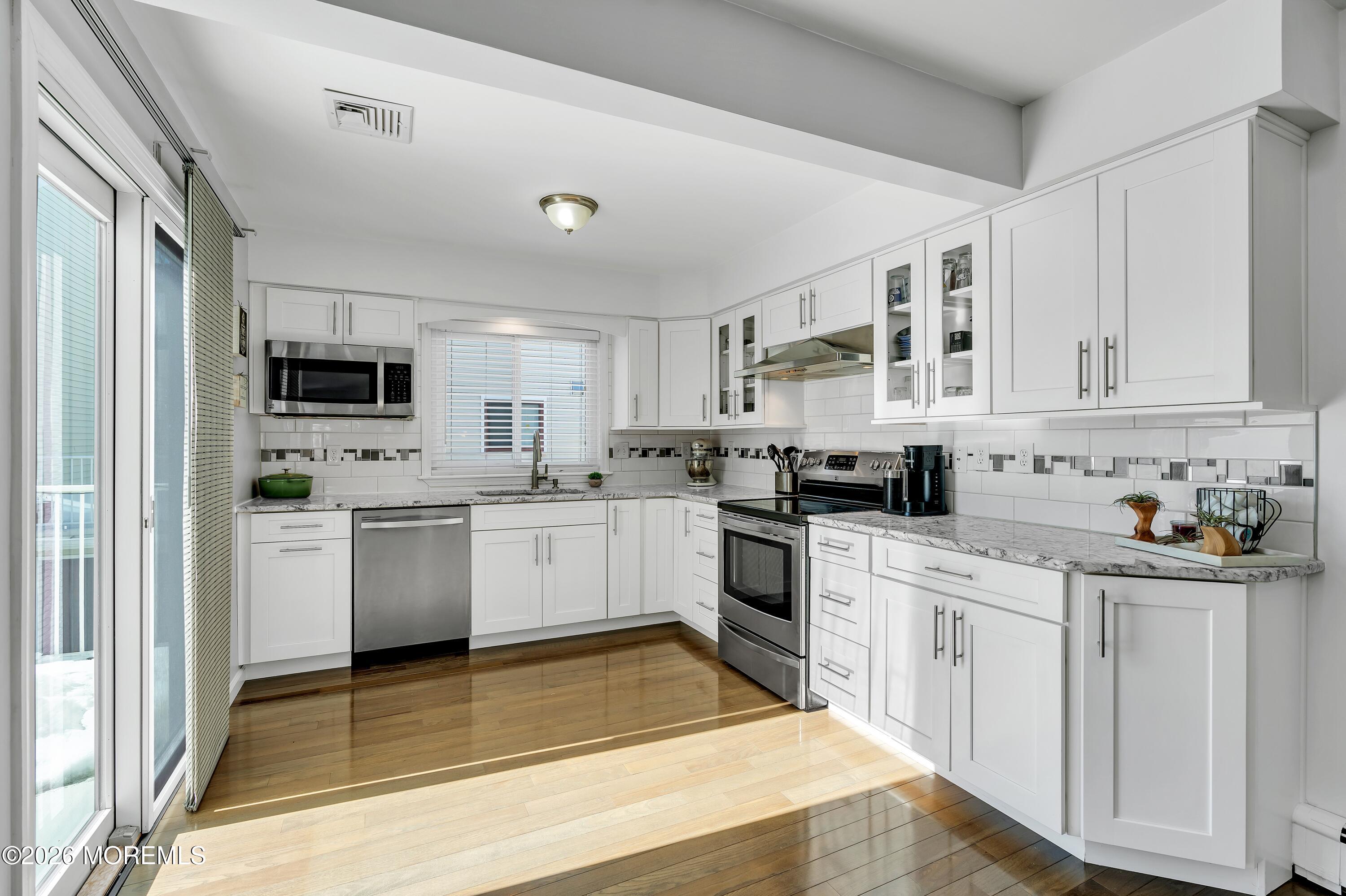 580 Patten Avenue, Unit 14 Long Branch, NJ 07740 - Photo 3 of 29 a kitchen with granite countertop white cabinets and white appliances