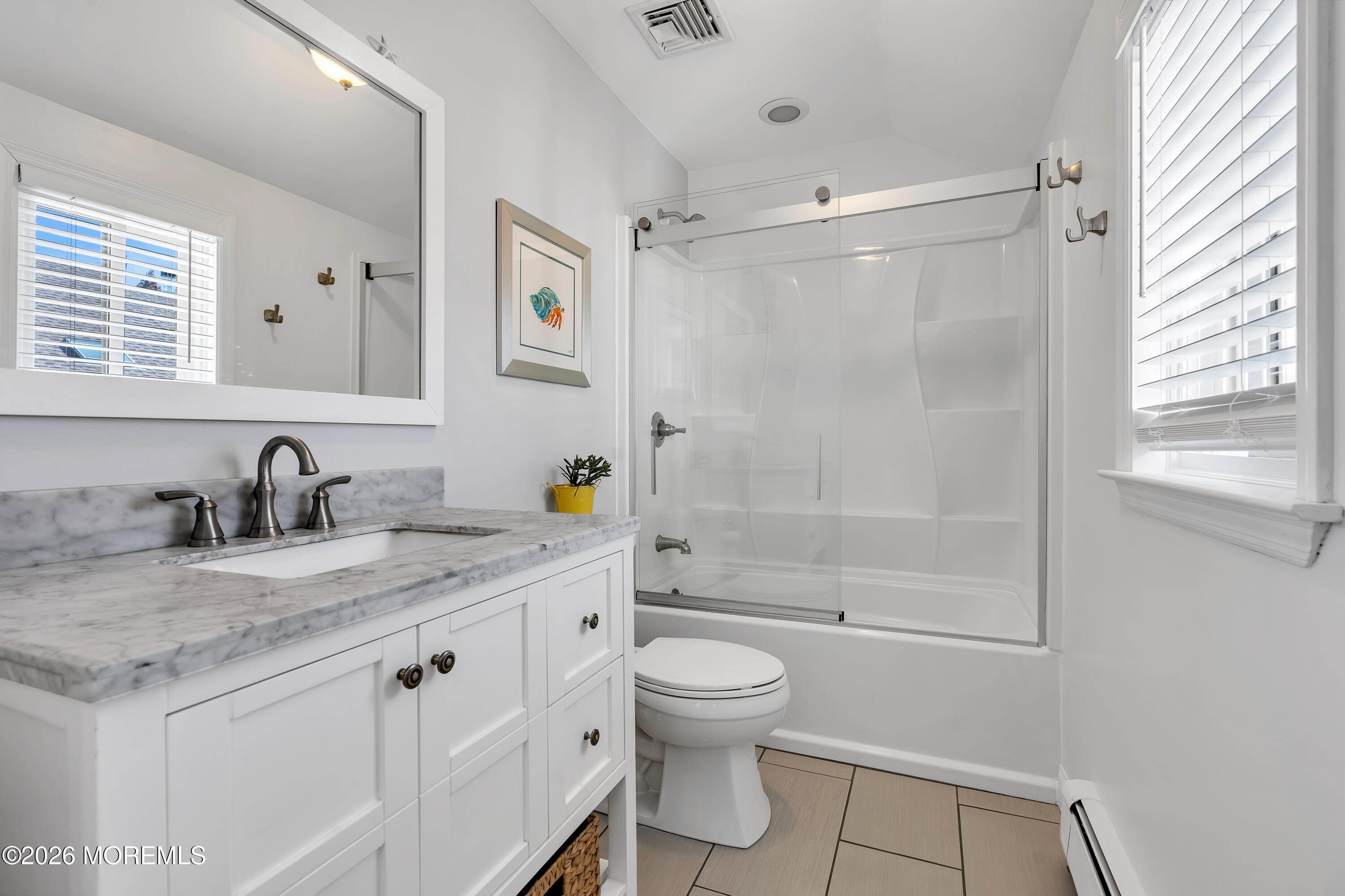 580 Patten Avenue, Unit 14 Long Branch, NJ 07740 - Photo 9 of 29 a bathroom with a granite countertop sink a toilet a mirror and shower