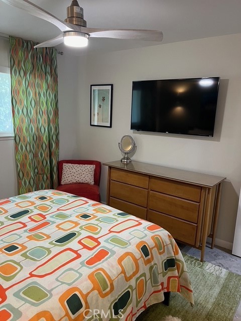 72724 Eagle Road, Unit 1 Palm Desert, CA 92260 - Photo 15 of 22 a bedroom with a bed a flat screen tv and a chandelier