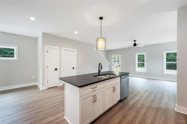 a kitchen with granite countertop a sink a counter space and wooden floor