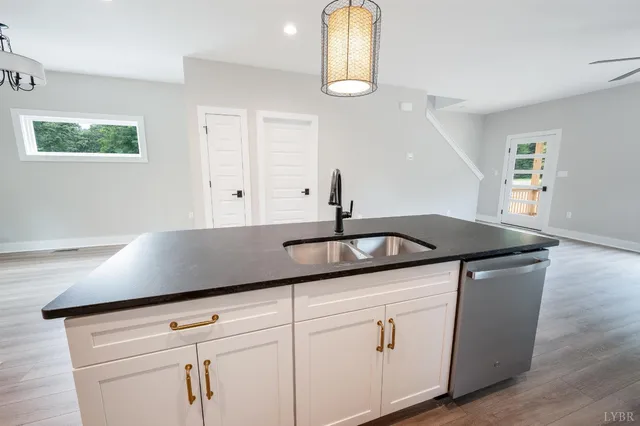 a kitchen with stainless steel appliances granite countertop a sink a stove a dining table and chairs