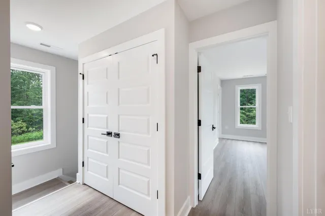 a view of a hallway with wooden floor and closet
