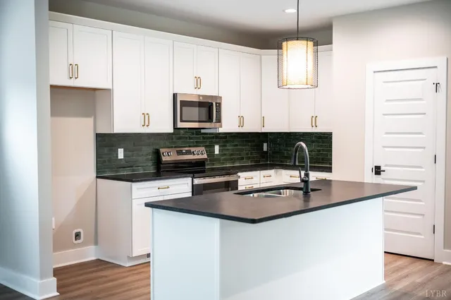 a kitchen with granite countertop a sink a stove and cabinets