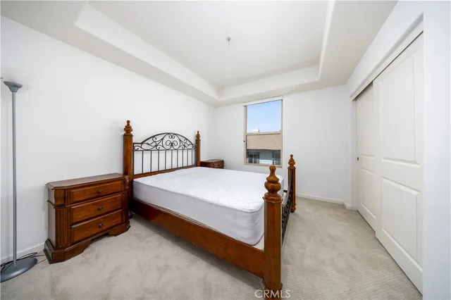 a room with a bed and a flat tv screen on wall