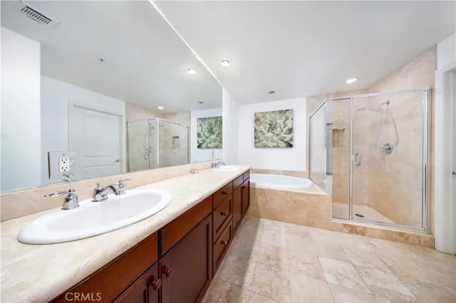 a spacious bathroom with a double vanity sink a toilet and a mirror