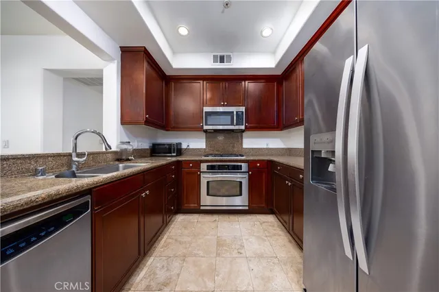 a kitchen with stainless steel appliances granite countertop a stove sink and refrigerator