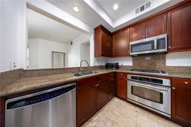 a kitchen with stainless steel appliances granite countertop a stove microwave and sink