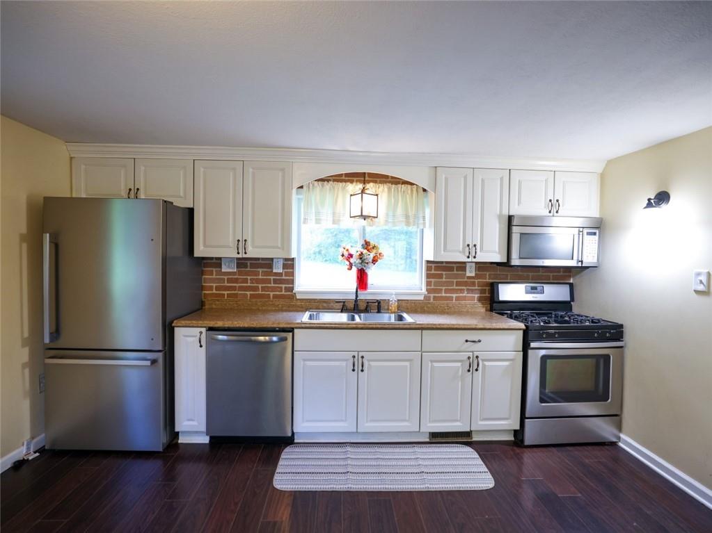 1381 Logan Road Gibsonia, PA 15044 - Photo 3 of 24 a kitchen with stainless steel appliances granite countertop a refrigerator sink and microwave