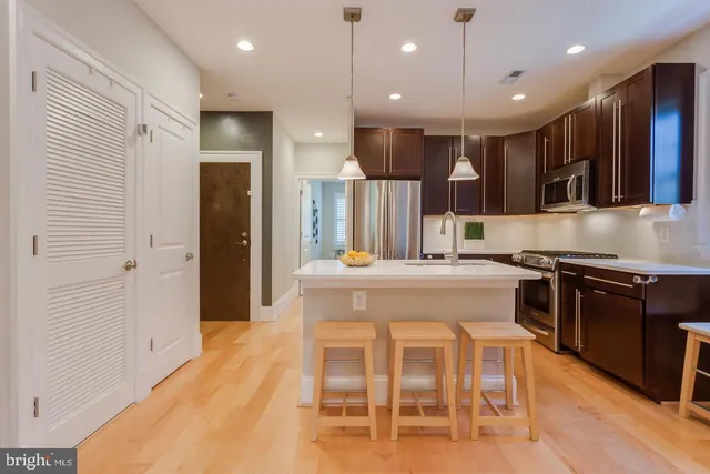 a kitchen with stainless steel appliances kitchen island granite countertop a stove and a refrigerator