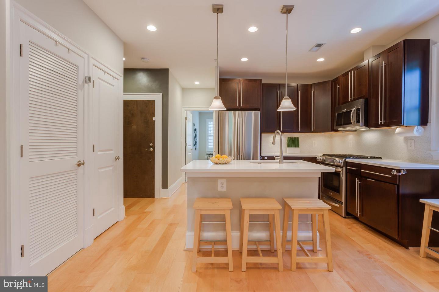 3937 Davis Place Northwest, Unit 3 Washington, DC 20007 - Photo 2 of 20 a kitchen with stainless steel appliances kitchen island granite countertop a stove and a refrigerator