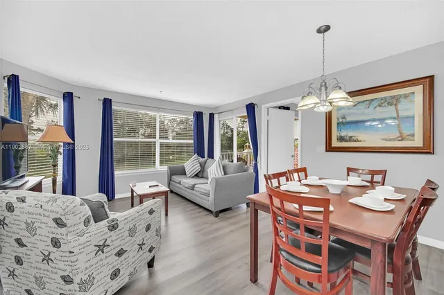a dining room with furniture a chandelier and wooden floor