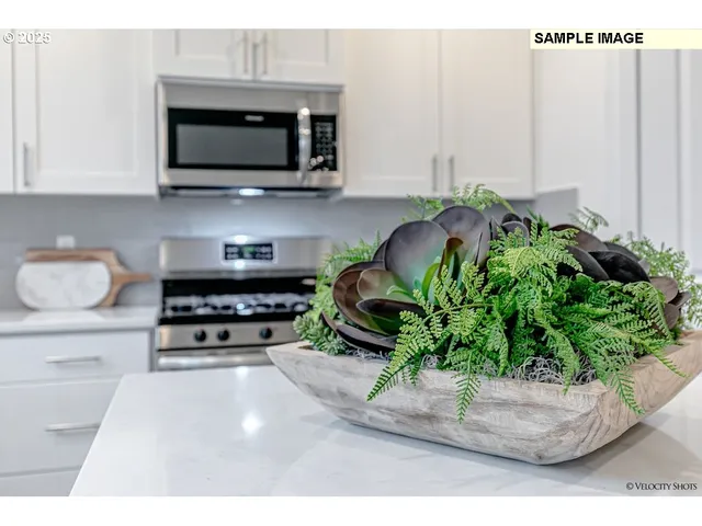 a kitchen with stainless steel appliances kitchen island granite countertop a refrigerator a stove a sink dishwasher and a dining table with wooden floor