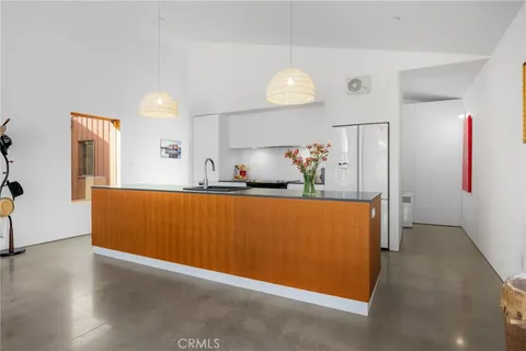 a kitchen with granite countertop stainless steel appliances a stove refrigerator and a sink