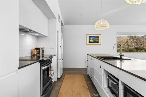 a kitchen with granite countertop a sink and a stove top oven
