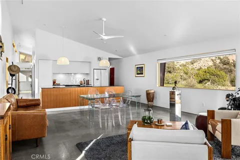 a view of a hallway with wooden floor and a bathroom