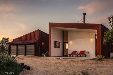 a view of a house with large windows and potted plants
