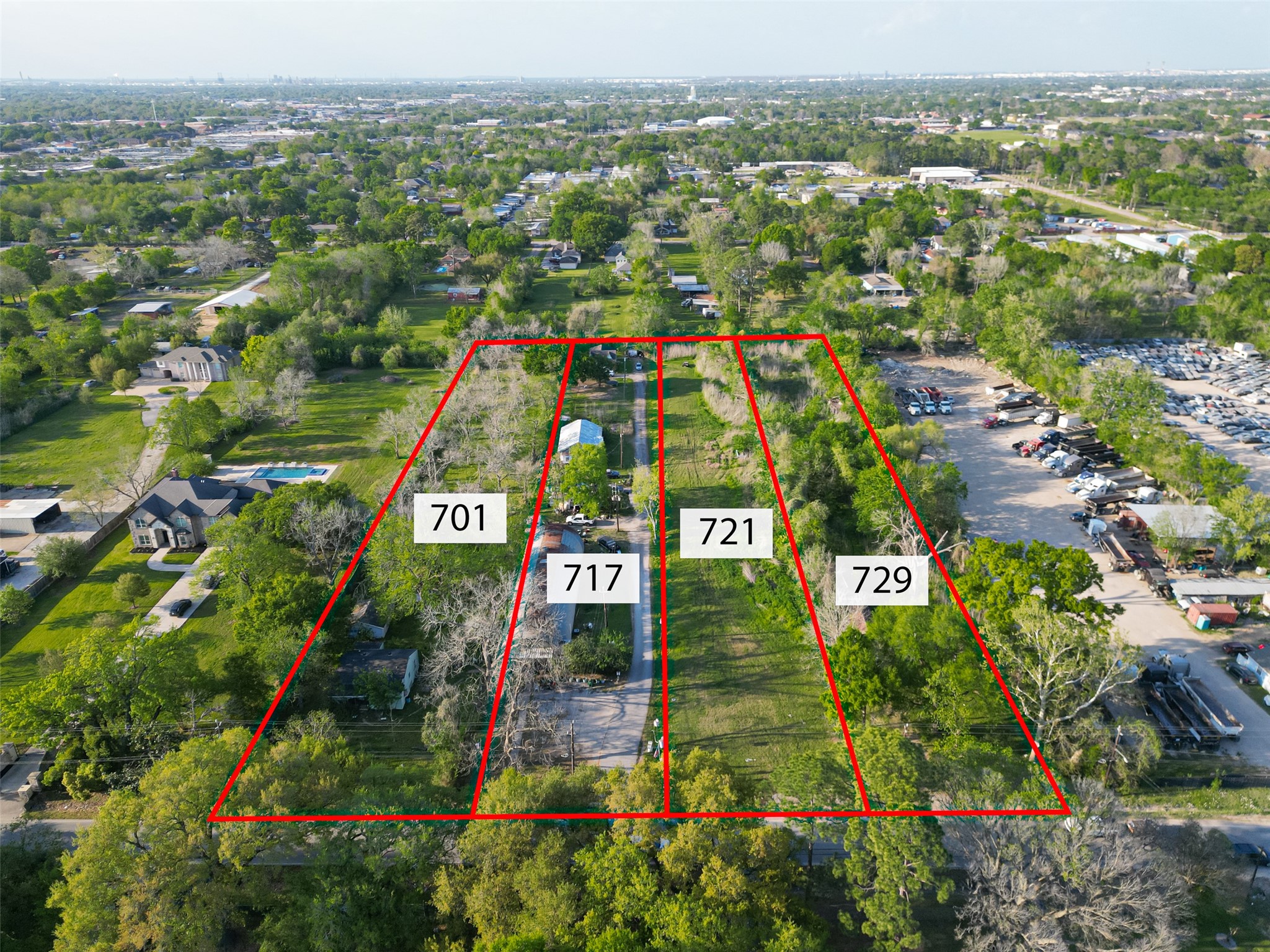 an aerial view of residential houses with outdoor space and trees