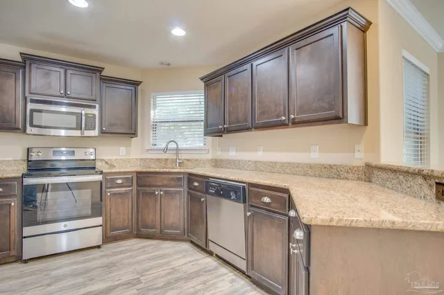 a kitchen with granite countertop stainless steel appliances and wooden cabinets