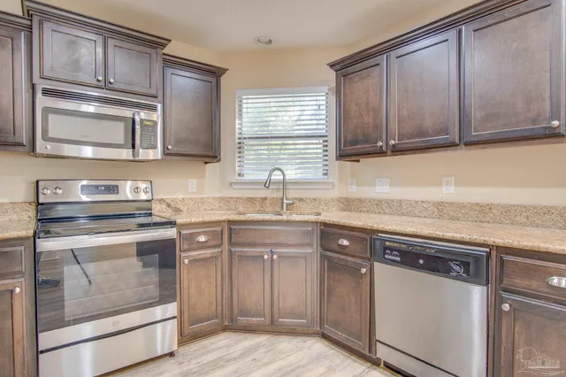 a kitchen with stainless steel appliances granite countertop a sink stove and cabinets