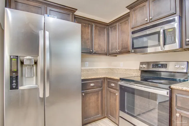 a kitchen with stainless steel appliances granite countertop a refrigerator and cabinets
