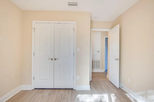 an empty room with windows and ceiling fan