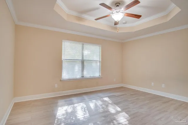 an empty room with a window and a fan