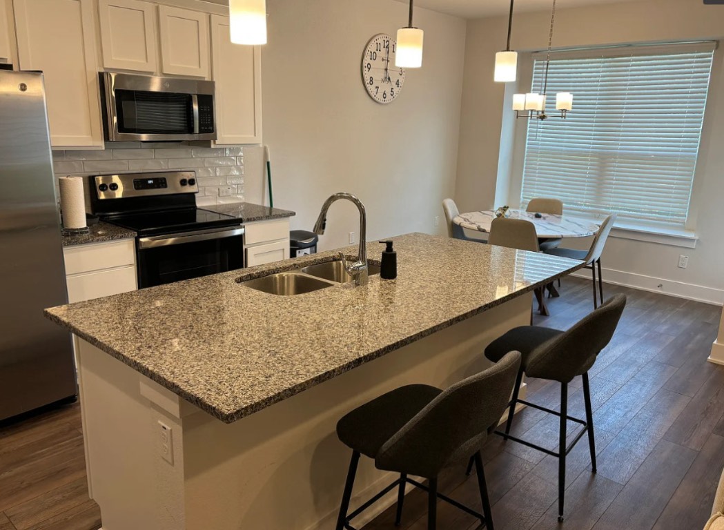 1709 Tun Tavern Trail Austin, TX 78754 - Photo 2 of 10 a kitchen with granite countertop sink table and chairs