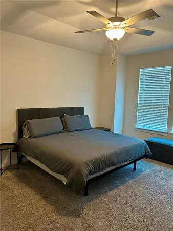 a bed sitting in a bedroom next to a window and a chandelier