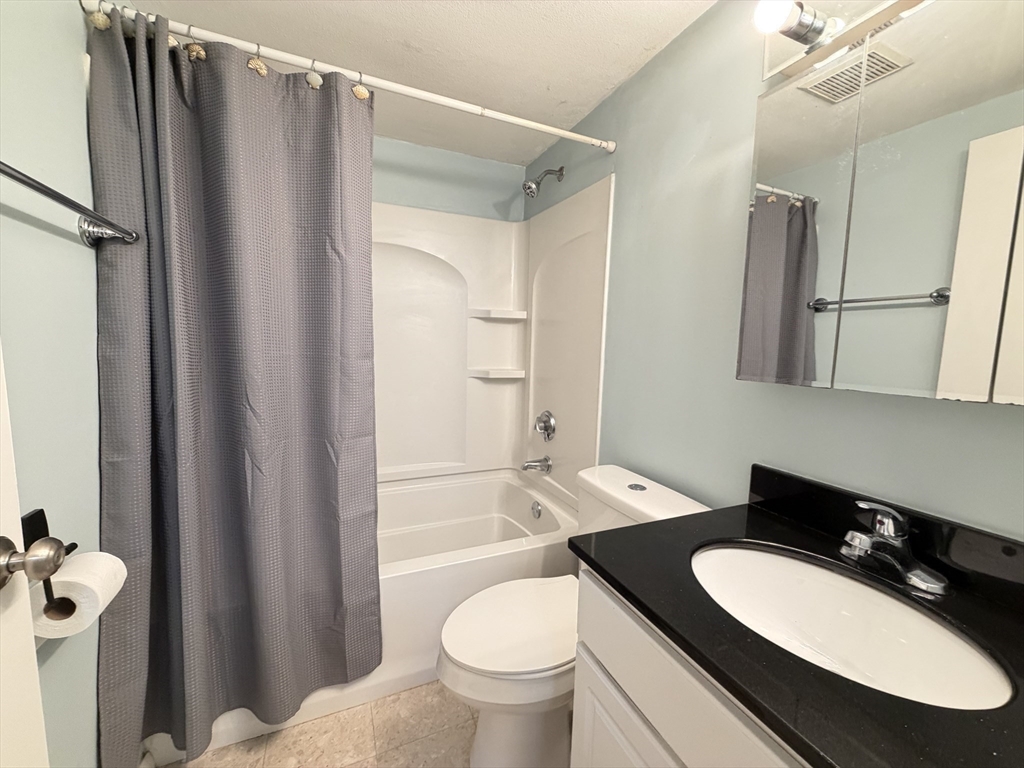 870 Haverhill Street, Unit 21B Rowley, MA 01969 - Photo 12 of 14 a bathroom with a granite countertop sink toilet and shower