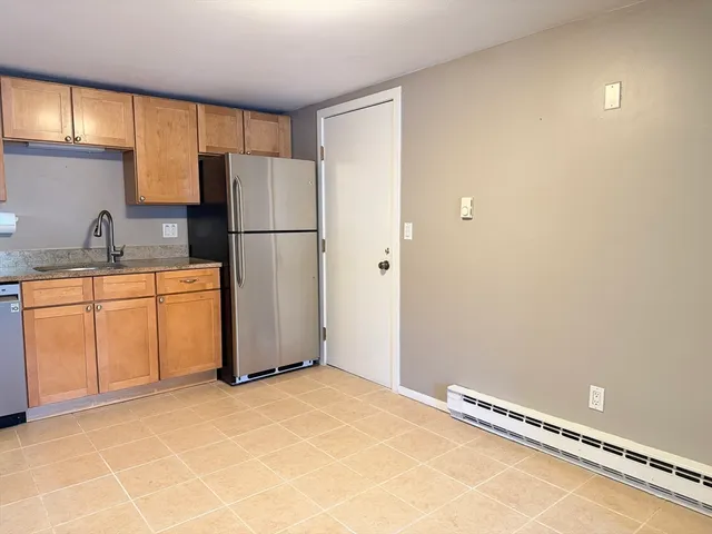 a kitchen with granite countertop a refrigerator stove top oven a sink and dishwasher