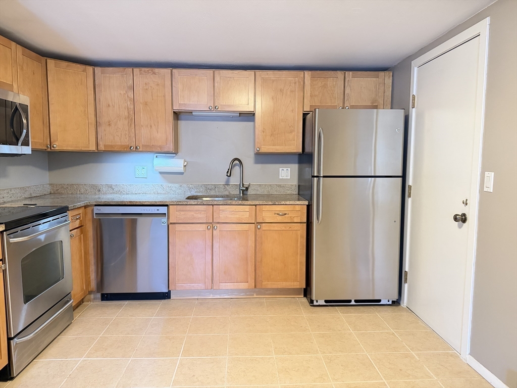 870 Haverhill Street, Unit 21B Rowley, MA 01969 - Photo 7 of 14 a kitchen with a refrigerator sink and cabinets