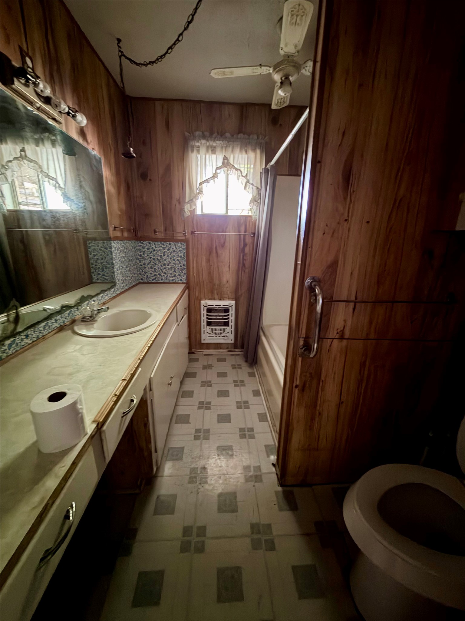 2501 Barnhardt Road Temple, TX 76502 - Photo 12 of 25 A compact bath featuring wood-paneled walls and a vanity with an integrated sink.