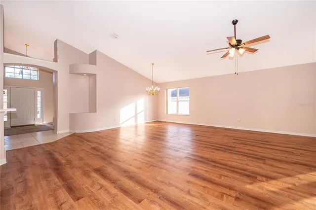a view of a room with wooden floor and a ceiling fan